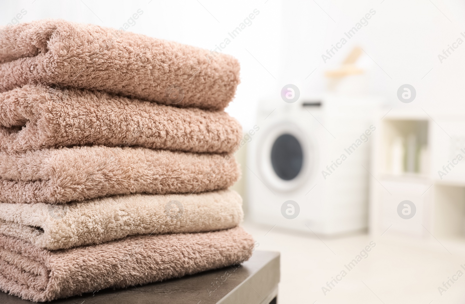 Photo of Stack of clean towels on table in bathroom.  Space for text