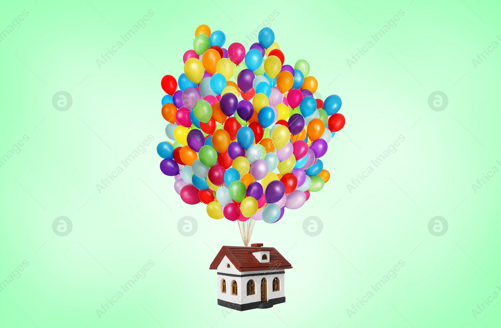 Image of Many balloons tied to model of house flying on aquamarine background