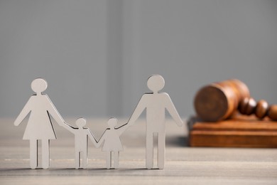 Photo of Family law. Figure of parents with children and gavel on wooden table, space for text