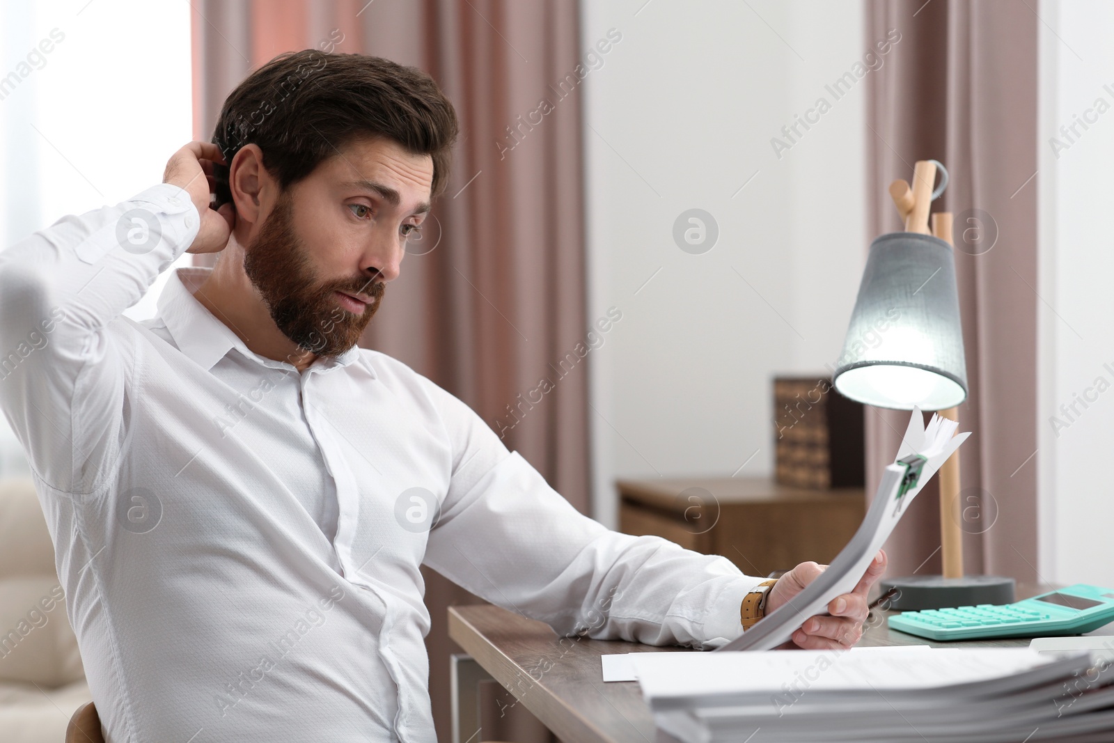 Photo of Businessman working with documents at wooden table in office