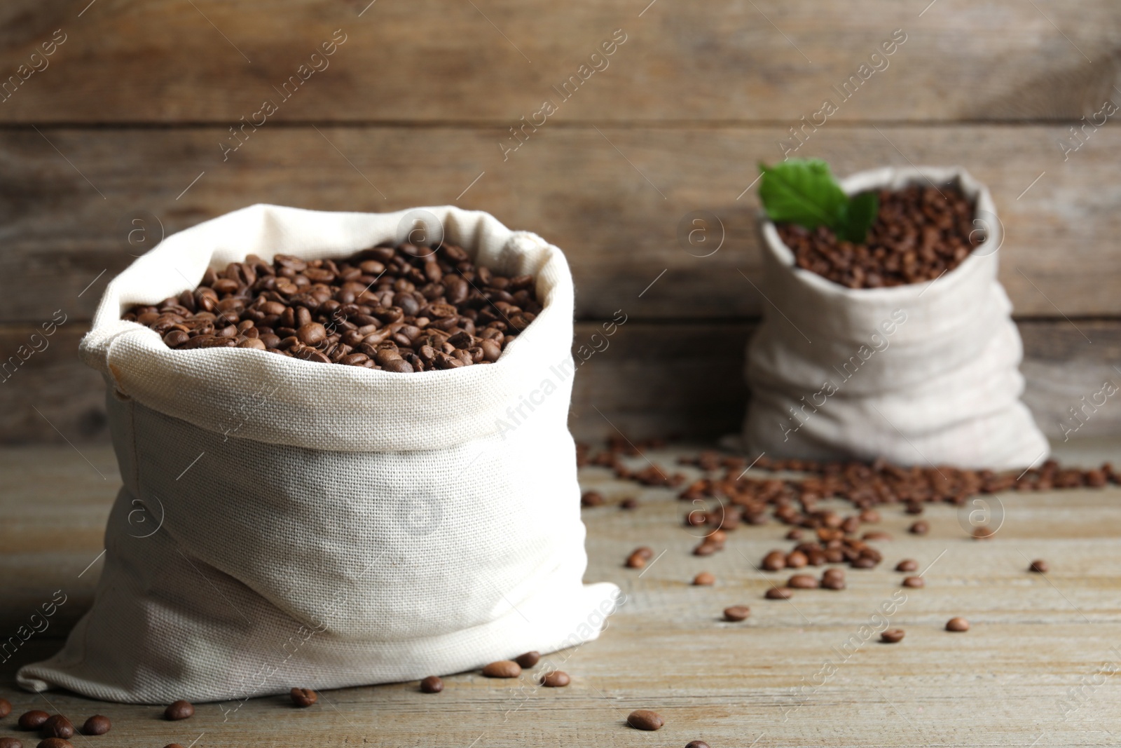 Photo of Bag of roasted coffee beans on wooden table. Space for text