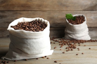 Photo of Bag of roasted coffee beans on wooden table. Space for text