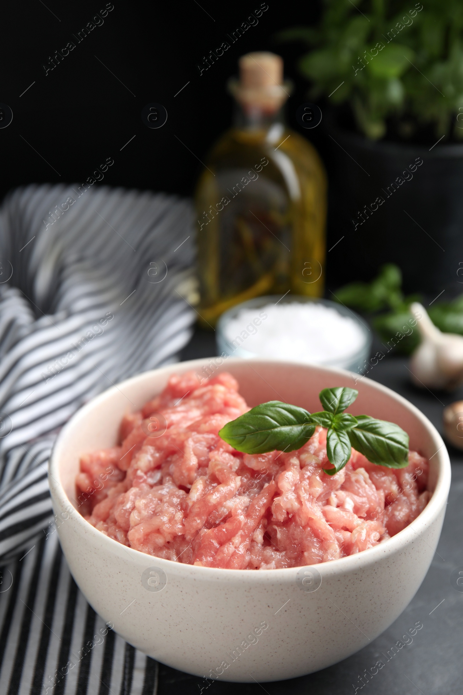 Photo of Raw chicken minced meat with basil on black table