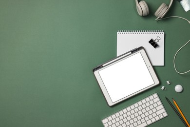 Photo of Flat lay composition with modern tablet on green background. Space for text