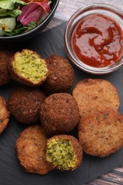 Photo of Delicious falafel balls and sauce on table, flat lay. Vegan meat products