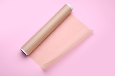 Photo of Roll of baking paper on pink background, top view