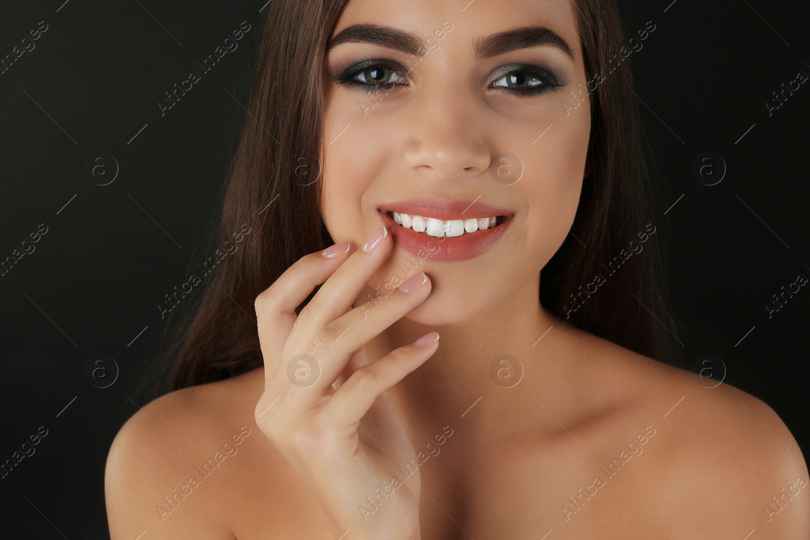 Photo of Portrait of beautiful woman with stylish makeup on dark background