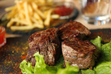 Photo of Tasty pieces of shish kebab served on slate plate in cafe