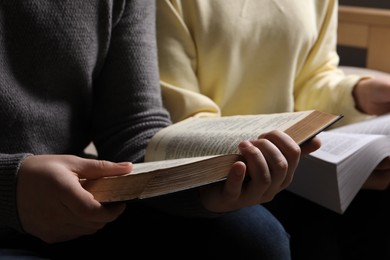 Photo of Couple reading Bibles in room, closeup view