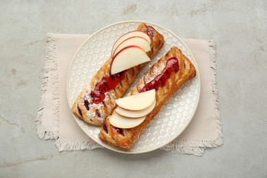 Fresh tasty puff pastry with jam and apples on white textured table, top view
