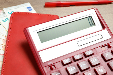 Photo of Calculator, notebook and money on wooden table, closeup. Tax accounting