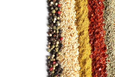 Photo of Rows of different aromatic spices on white background, top view with space for text