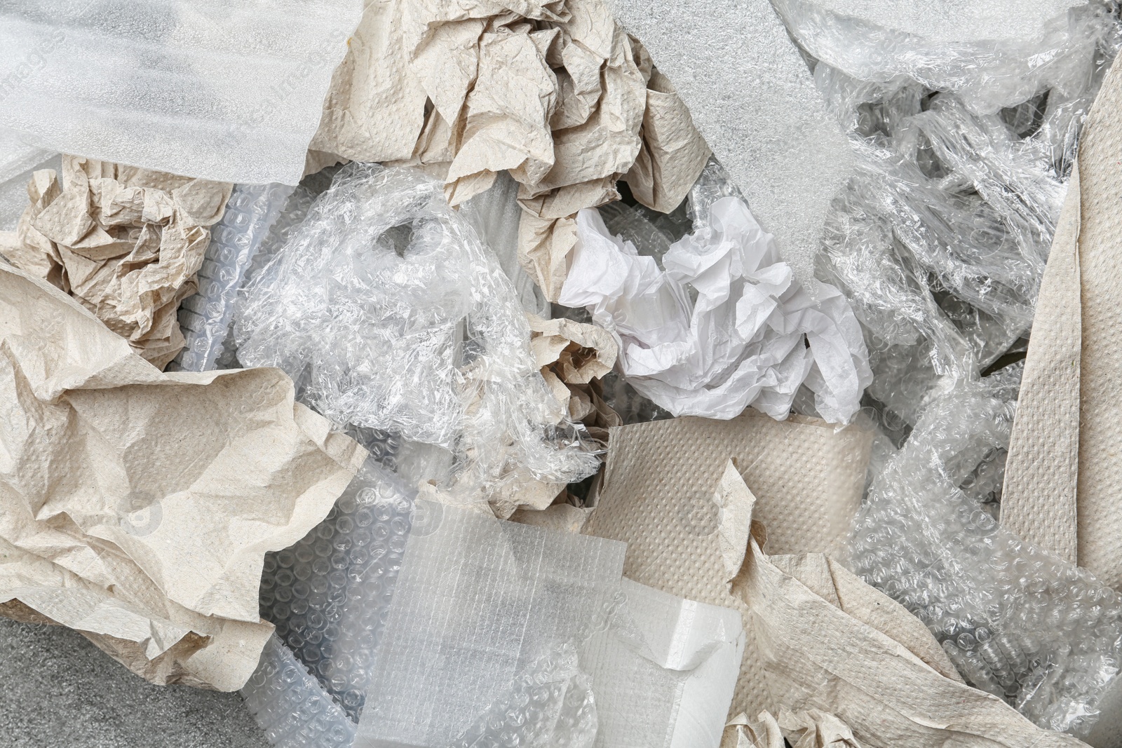 Photo of Pile of paper and plastic garbage as background, top view. Recycling problem
