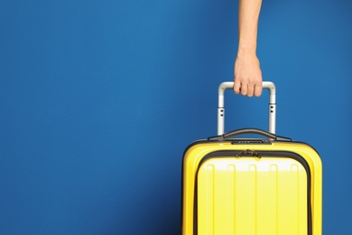 Photo of Woman with stylish suitcase against color background, closeup. Space for text