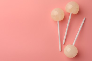 Tasty lollipops on pink background, flat lay. Space for text