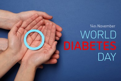 Image of World Diabetes Day. People holding blue paper circle on color background, top view