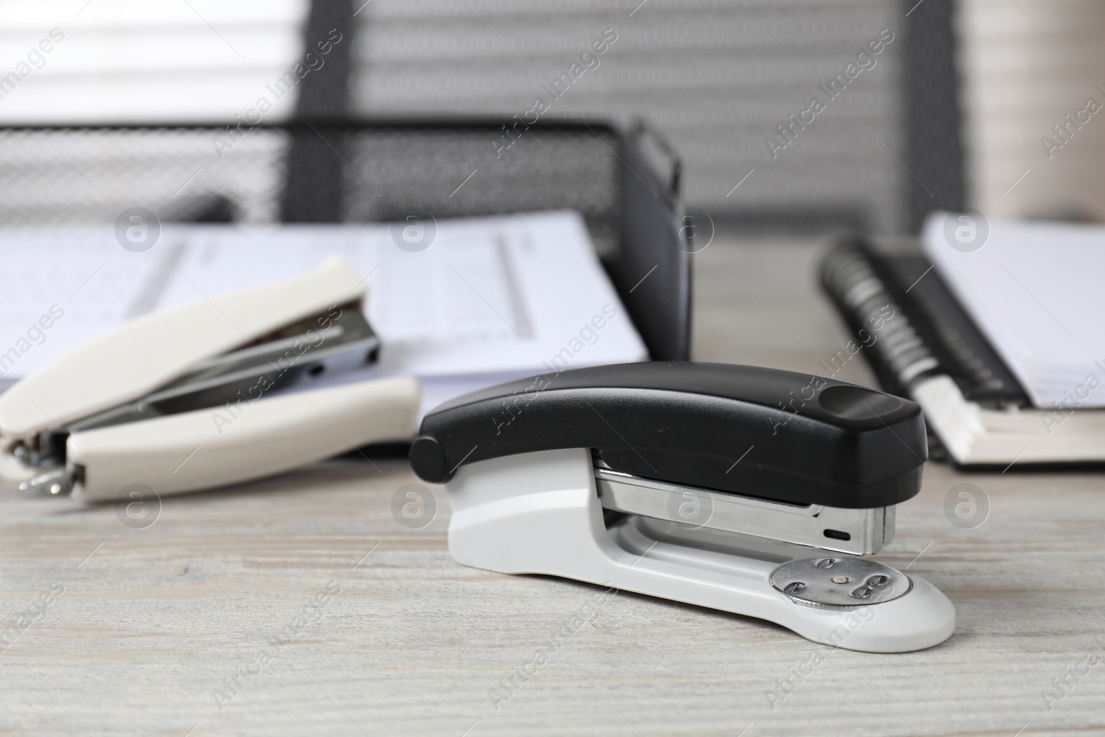 Photo of Stapler on wooden table indoors, closeup. Office stationery