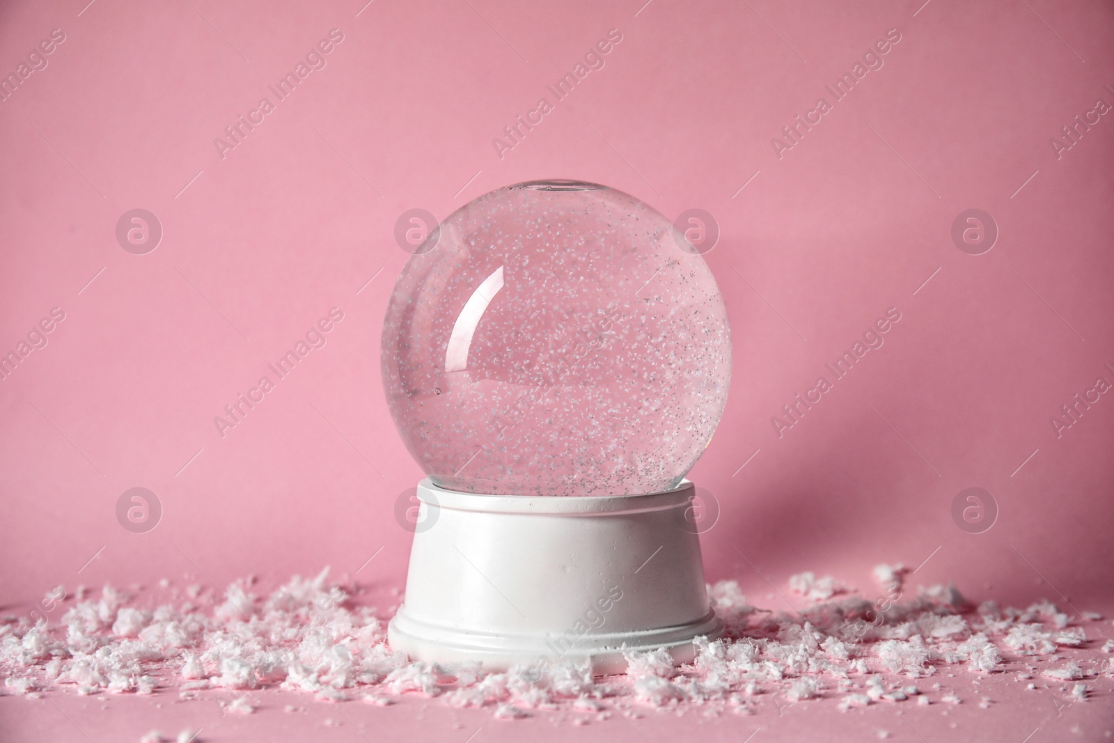 Photo of Magical empty snow globe on color background