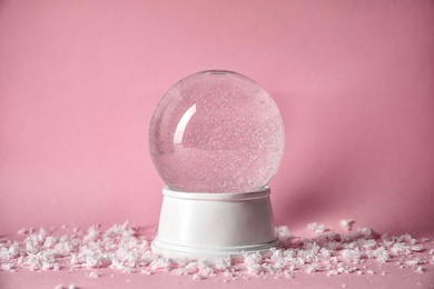 Magical empty snow globe on color background