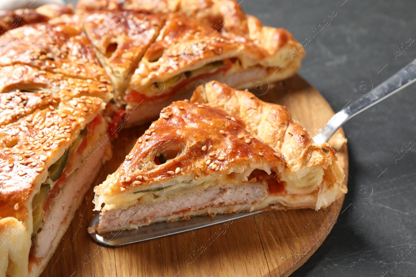 Photo of Cut delicious homemade pie and server on black table, closeup