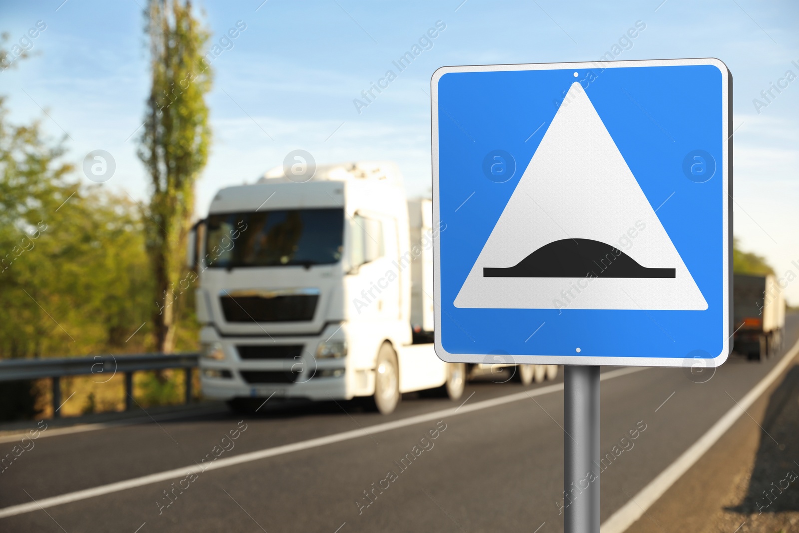 Image of Sign Speed Bump near asphalt road outdoors 