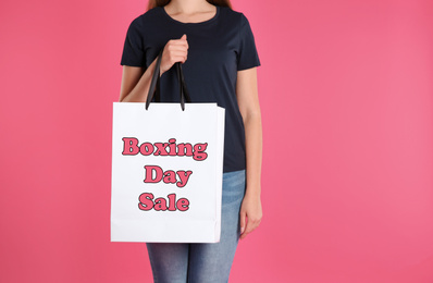Image of Boxing day sale. Woman with shopping bag on pink background