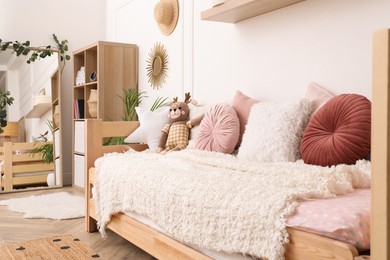 Photo of Cute child's room interior with comfortable bed and mirror