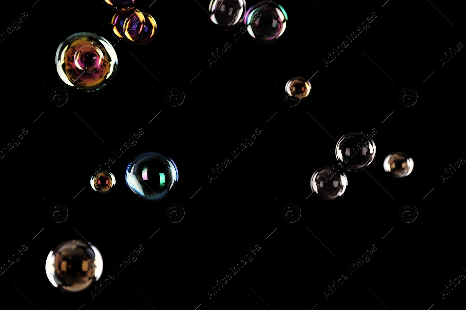 Photo of Beautiful translucent soap bubbles on dark background