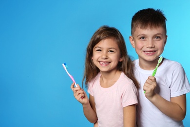 Portrait of cute children with toothbrushes on color background. Space for text