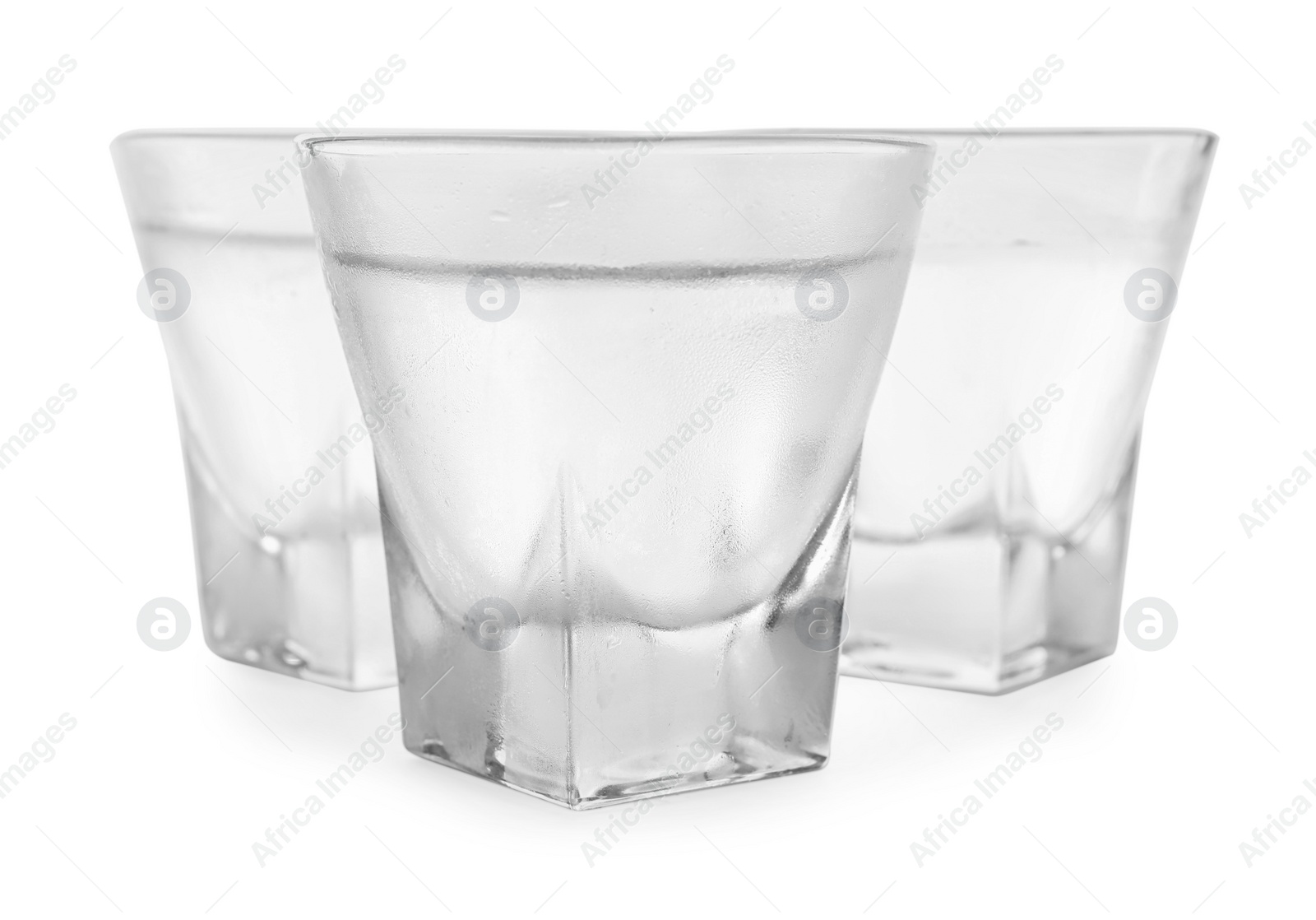 Photo of Vodka in shot glasses on white background