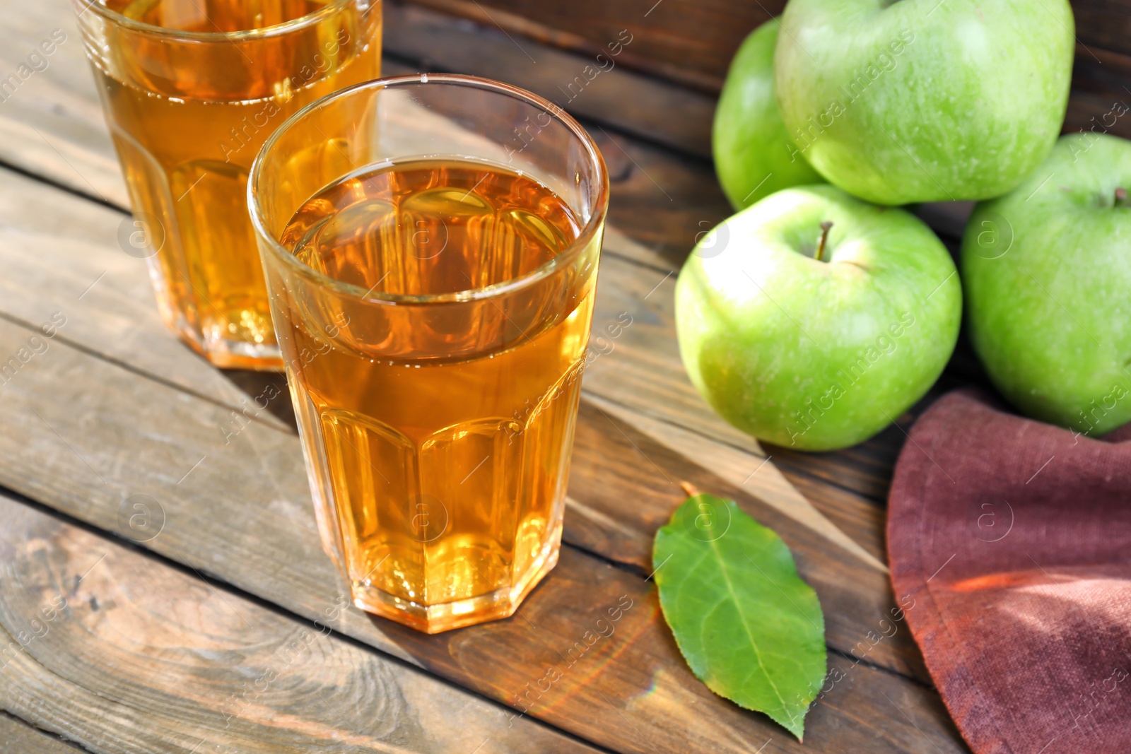 Photo of Two glasses of fresh apple juice on wooden table