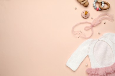 Baby clothes and accessories on light pink background, flat lay. Space for text