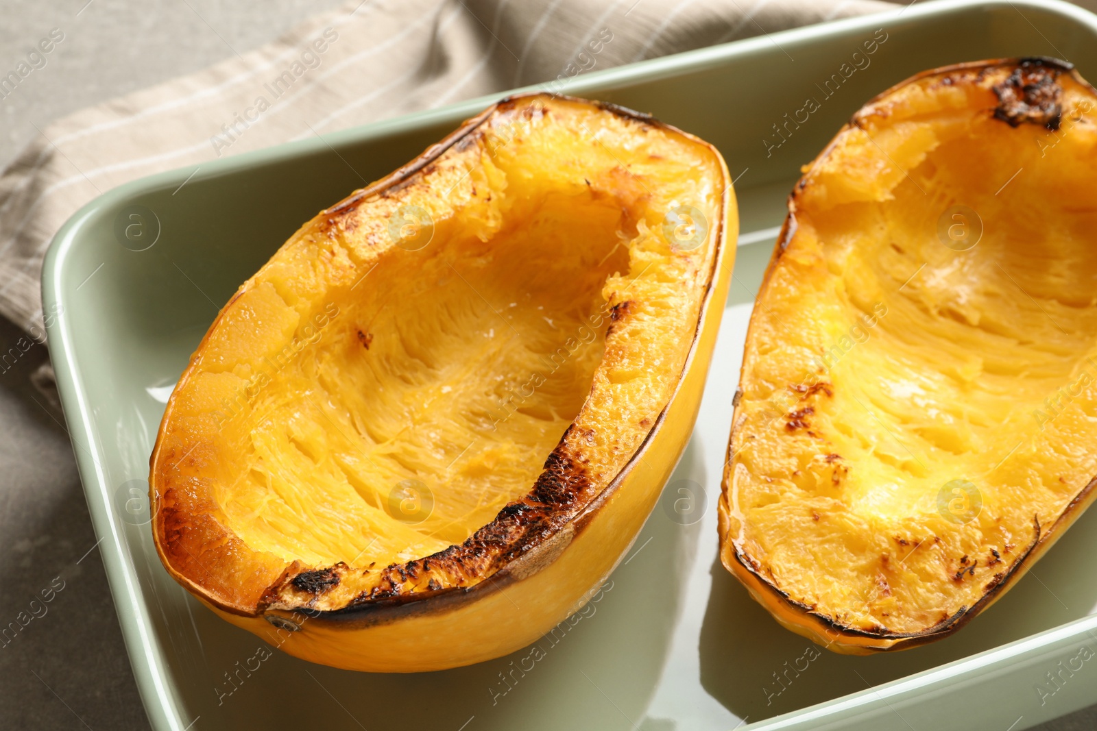 Photo of Cooked spaghetti squash in baking dish on table, closeup