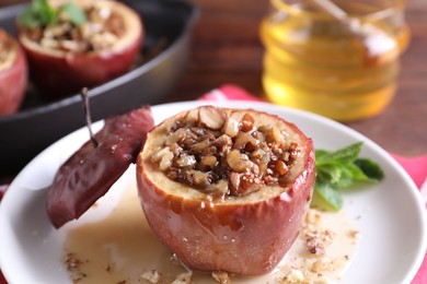 Tasty baked apple with nuts and honey on table, closeup