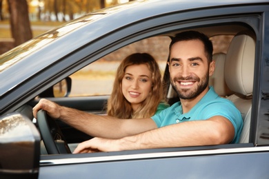 Photo of Young man sitting in car with passenger. Driving license test