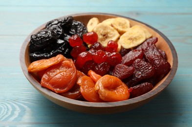 Photo of Mix of delicious dried fruits on light blue wooden table