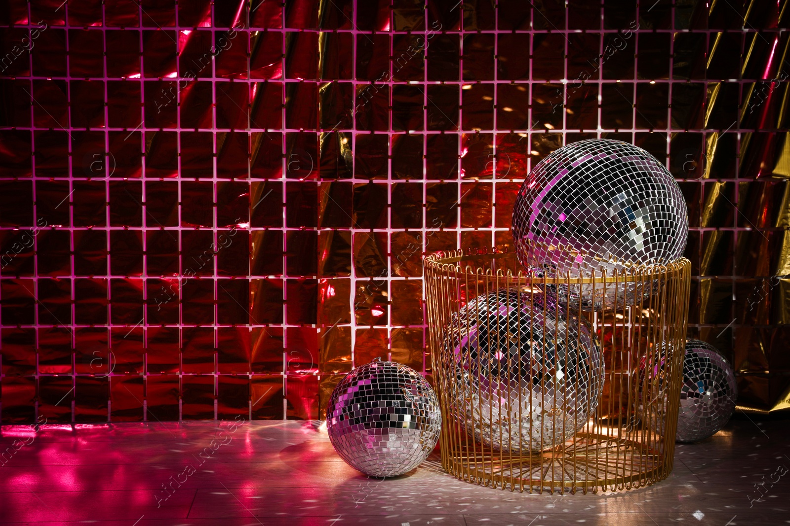 Photo of Many shiny disco balls on floor near foil party curtain. Space for text