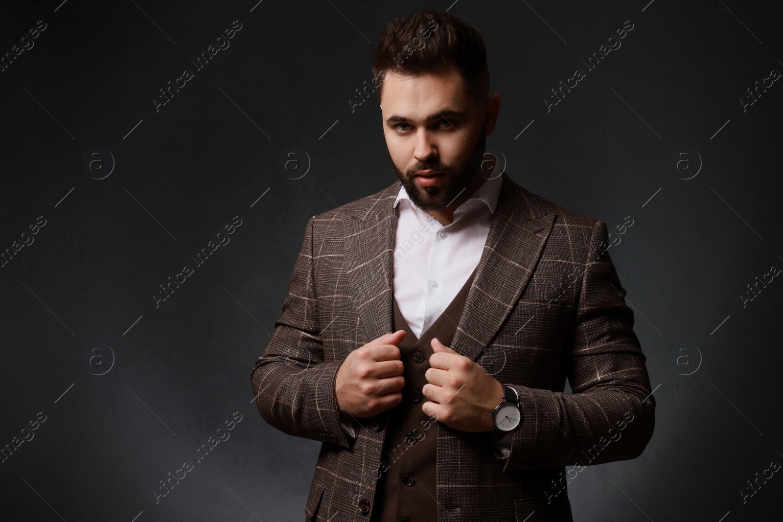 Photo of Handsome bearded man in stylish suit on dark background