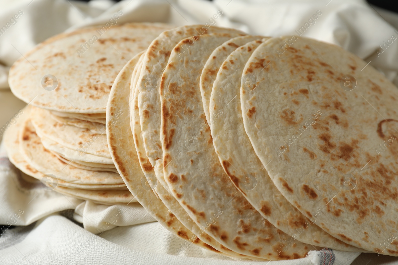 Photo of Tasty homemade tortillas and cloth on table