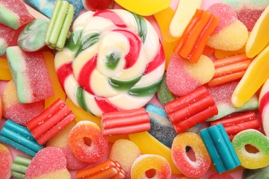 Photo of Many different jelly candies and lollipop as background, top view