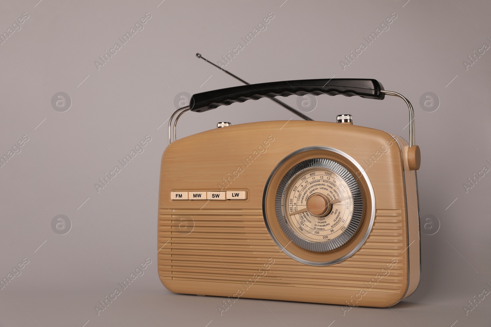 Photo of Portable retro radio receiver on grey background
