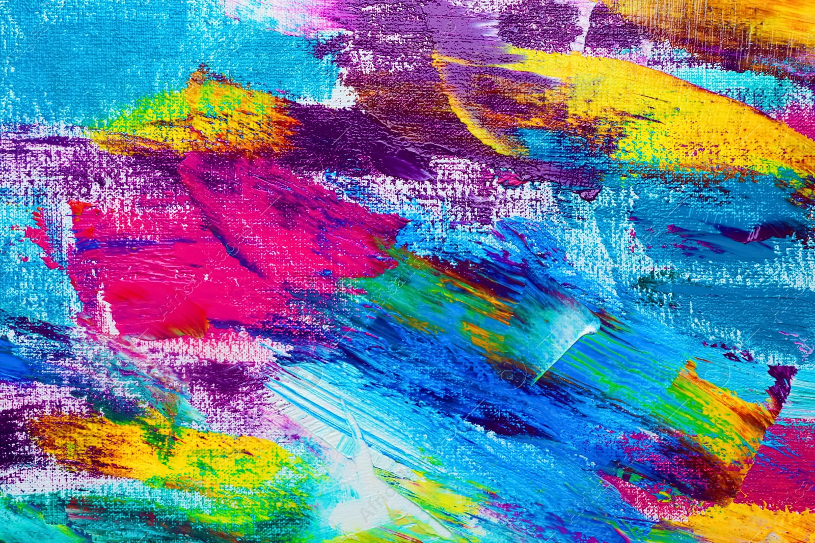 Photo of Strokes of colorful acrylic paints on canvas, closeup