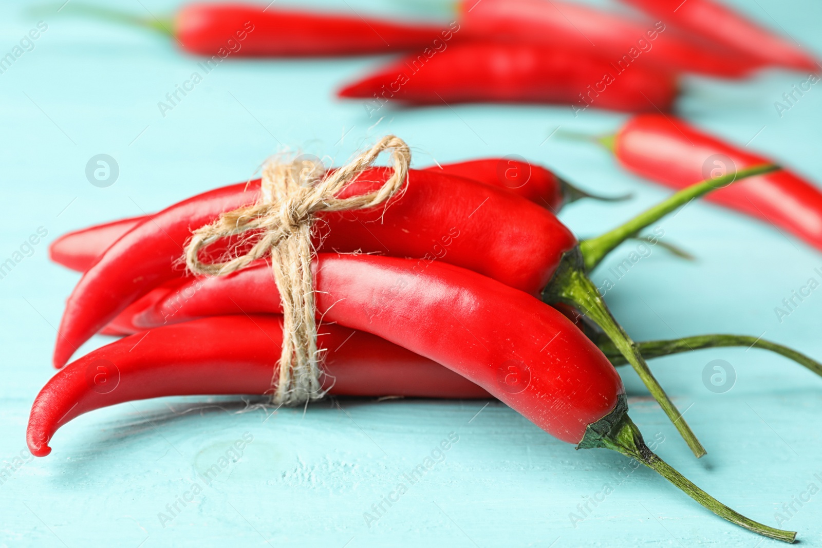 Photo of Red hot chili peppers on light blue wooden table, closeup