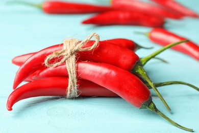 Red hot chili peppers on light blue wooden table, closeup