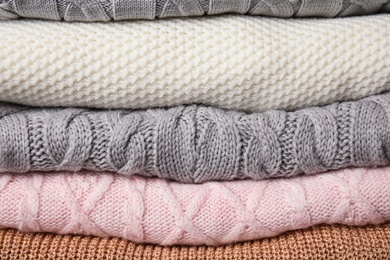 Photo of Stack of knitted clothes as background. Cozy autumn