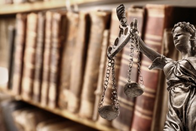 Law and wisdom. Statue of Lady Justice near shelves with books, space for text