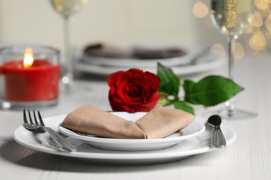 Photo of Beautiful table setting with burning candle and rose for romantic dinner, closeup
