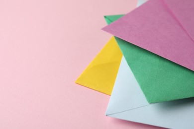 Colorful paper envelopes on pink background, closeup. Space for text