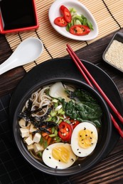 Delicious vegetarian ramen served on wooden table, flat lay. Noodle soup