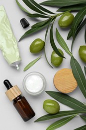 Photo of Cosmetic products with olive essential oil on light grey background, flat lay